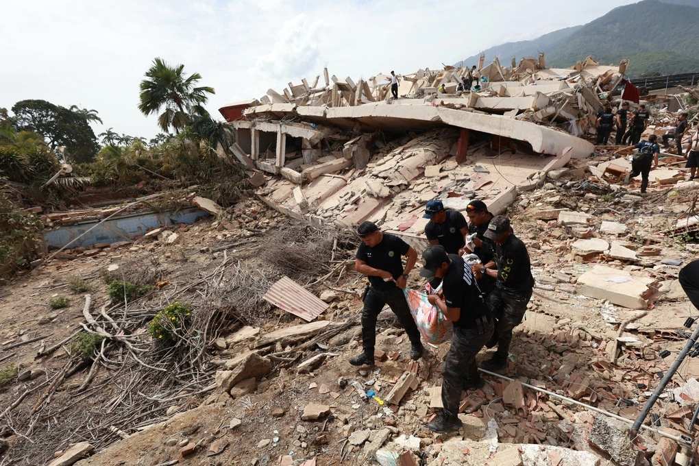 Cảnh sát khiêng thi thể được tìm thấy trong đống đổ nát ở La Guaira, Venezuela, ngày 25/6. Ảnh: AP
