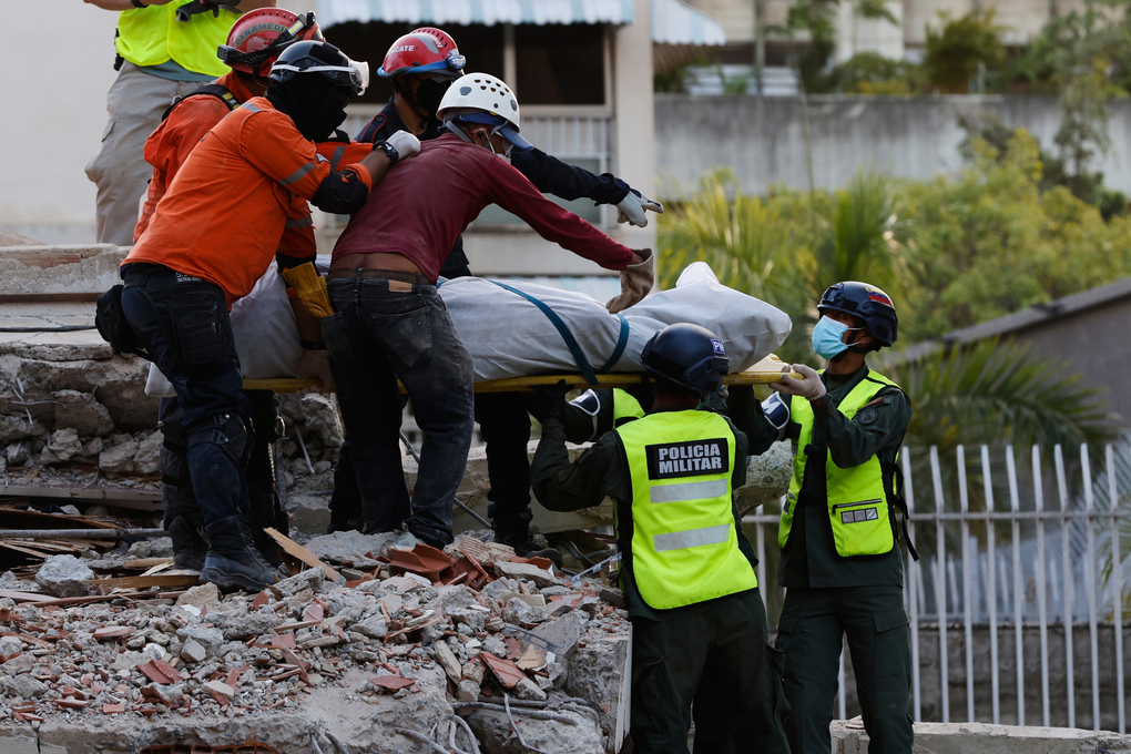 Lực lượng cứu hộ đưa một thi thể ra khỏi đống đổ nát tại Caracas, Venezuela ngày 26/6. Ảnh: AP