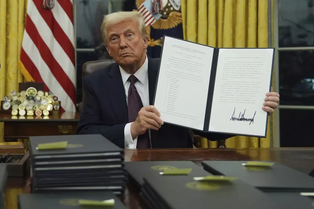Tổng thống Donald Trump ký sắc lệnh vào ngày đầu tiên nhậm chức nhiệm kỳ hai 20/1/2025. Ảnh: AP
