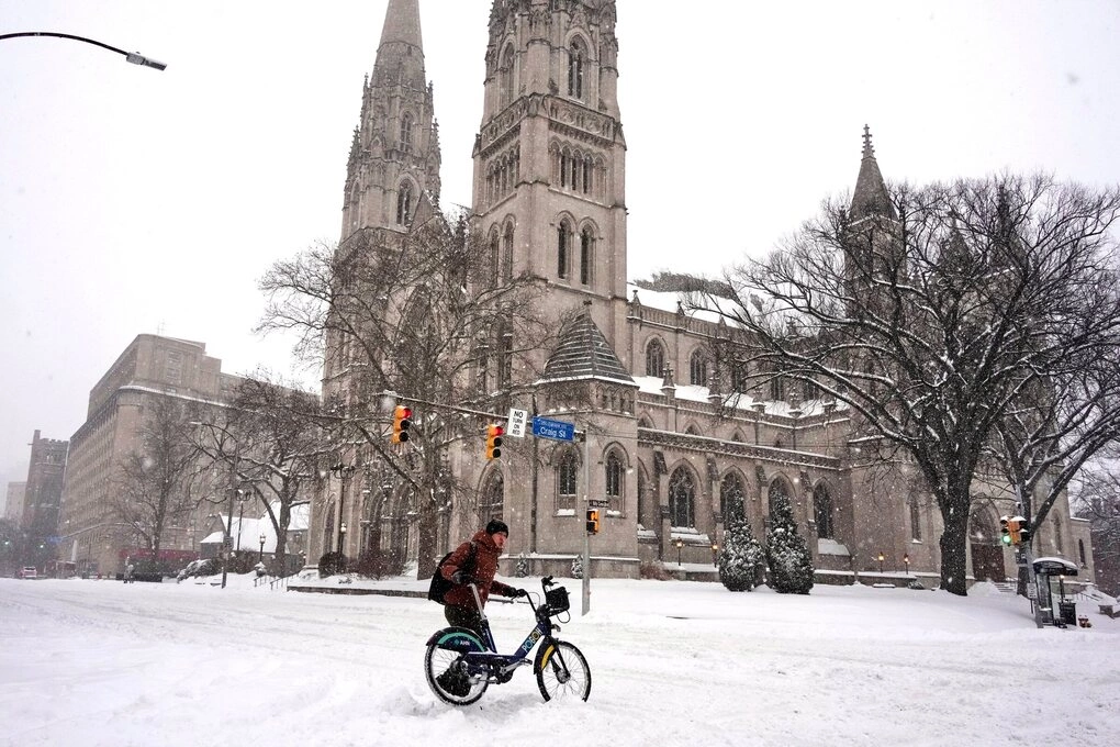 Sinh viên đẩy xe đạp qua đường ở Pittsburgh, Pensylvania hồi tháng 1. Ảnh: AP