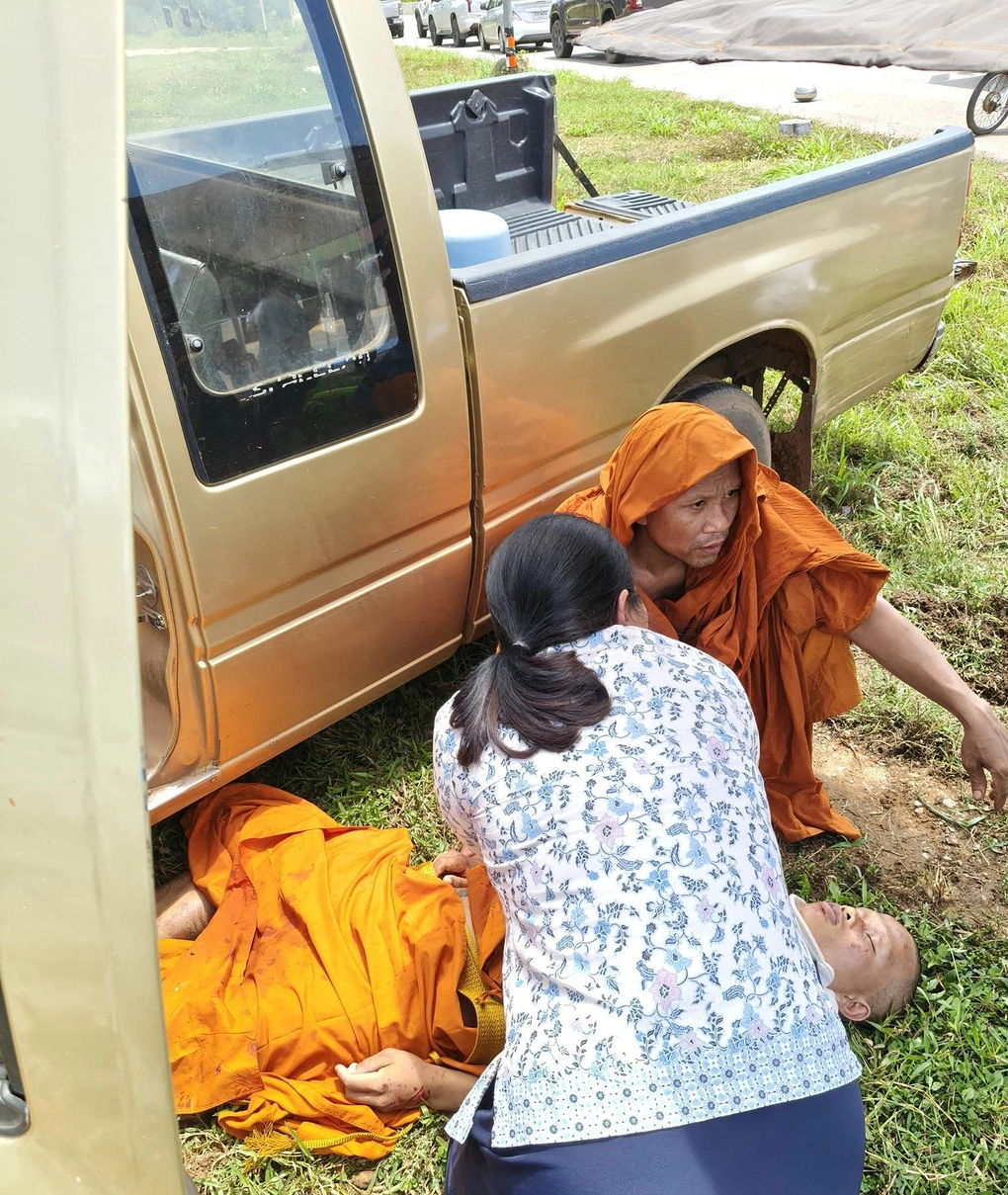 Nữ y tá Wiwat Laonoi hỗ trợ các nhà sư bị bé trai 11 tuổi tông xe ở tỉnh Mukdahan, đông bắc Thái Lan, hôm 2/7. Ảnh: AFP