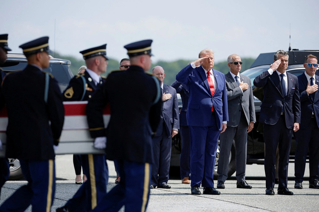 Tổng thống Mỹ Donald Trump (cà vạt đỏ) giơ tay chào khi các binh sĩ di chuyển thi hài quân nhân Isabella Gonzales từ máy bay tại căn cứ không quân Dover, bang Delaware ngày 22/7. Ảnh: Reuters