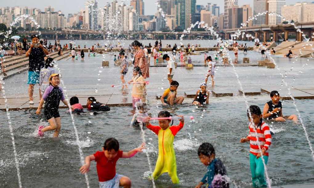 Trẻ em chơi đùa trong đài phun nước tại Seoul, Hàn Quốc hôm 31/7. Ảnh: Reuters