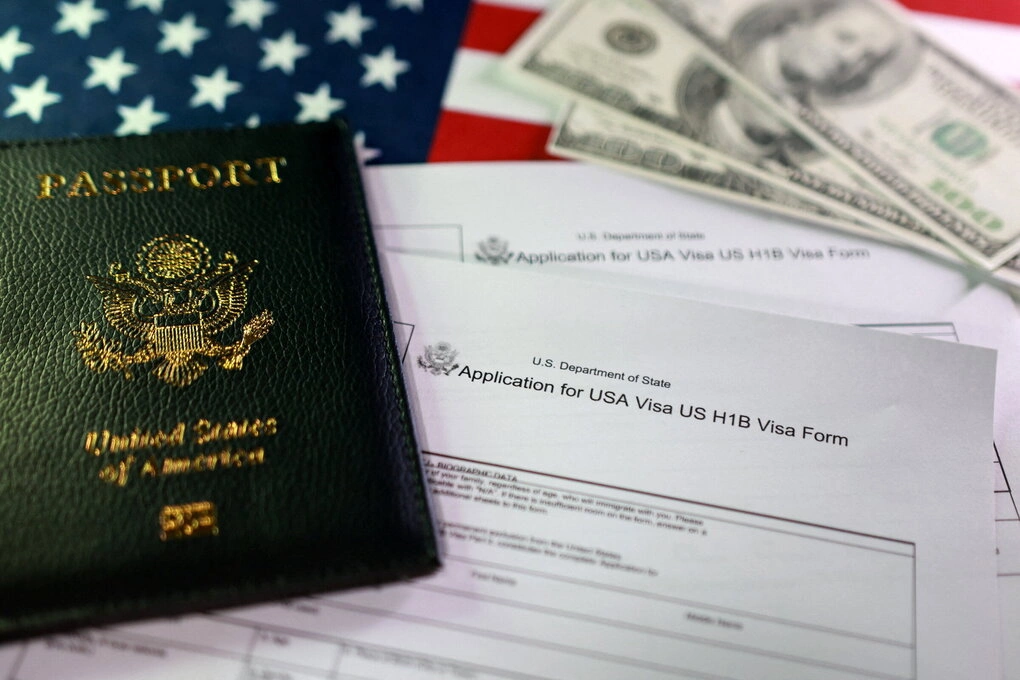 Mẫu đơn xin visa H-1B cùng một hộ chiếu Mỹ trong ảnh chụp tháng 9/2025. Ảnh: Reuters