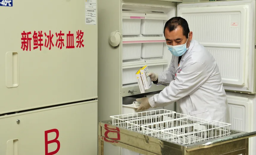 Một nhân viên ngân hàng máu đang thực hiện quá trình tách và chuẩn bị huyết tương đông lạnh tươi tại Thương Châu, tỉnh Hà Bắc, Trung Quốc, ngày 15/1/2021. Ảnh: CFOTO