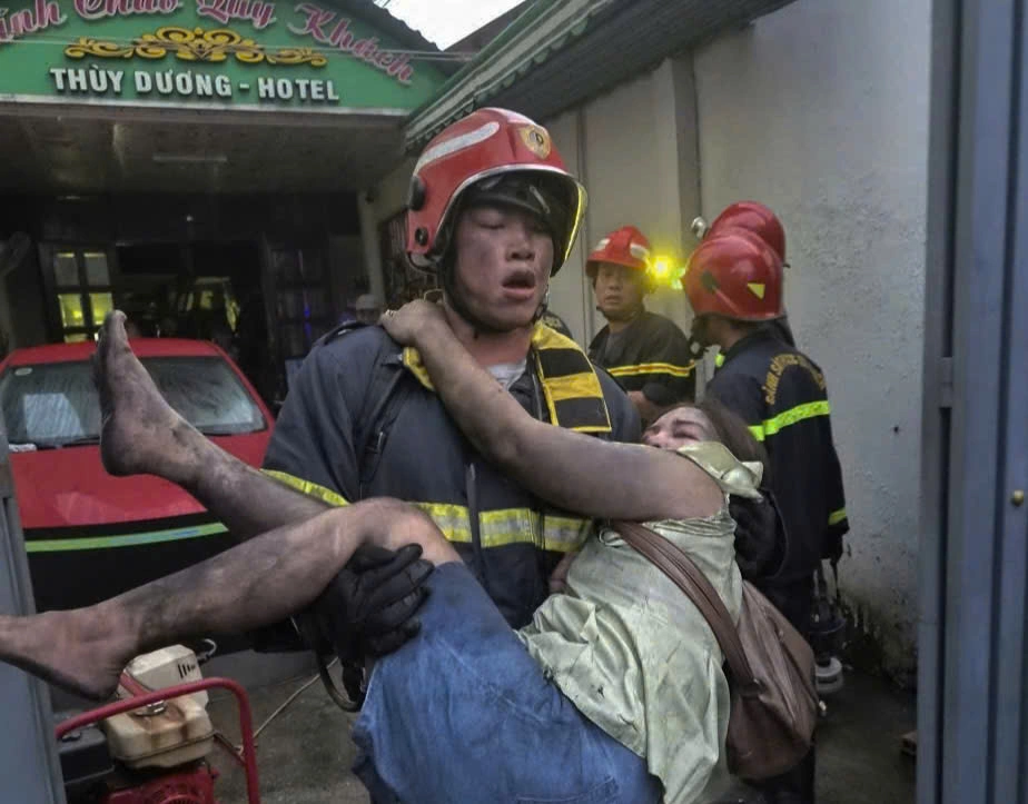 Lính cứu hỏa cứu người mắc kẹt ra ngoài. Ảnh: Phạm Lâm