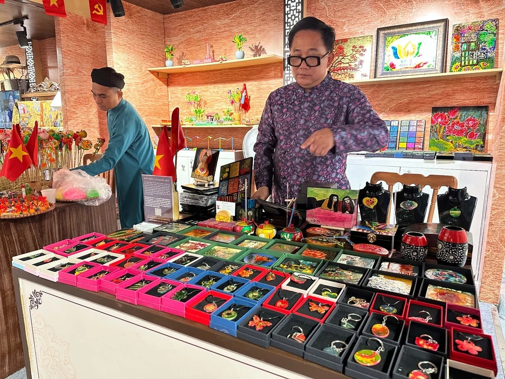 Họa sĩ Trần Anh Tuấn và nghệ nhân Đặng Đình Thường tại gian hàng ở hội chợ. Ảnh: BT