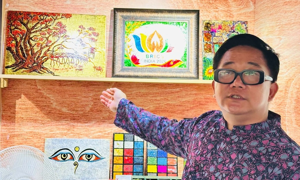 Họa sĩ Trần Anh Tuấn giới thiệu các sản phẩm sơn mài trưng bày tại hội chợ. Ảnh: BT
