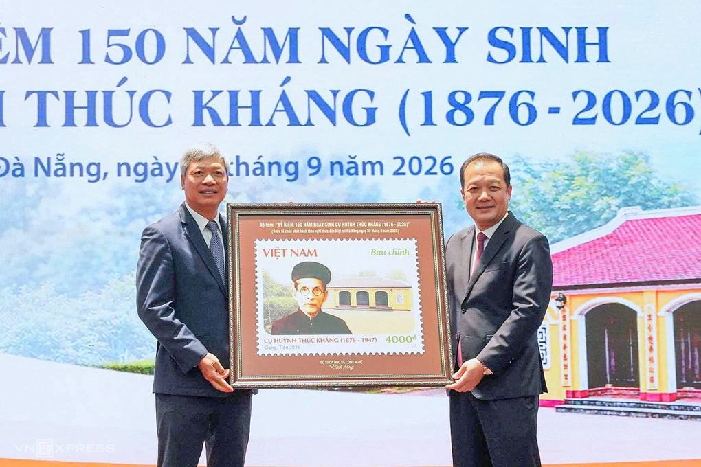 Deputy Minister of Science and Technology Pham Duc Long (right) presented the stamp painting to Vice Chairman of the City People's Committee Ho Quang Buu. Photo: Dong Cong