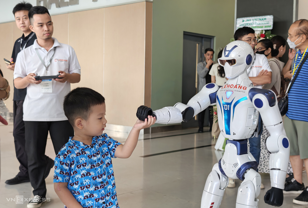 Humanoid robot interacts with a child guest at a technology event in Ho Chi Minh City. Photo: Bao Lam