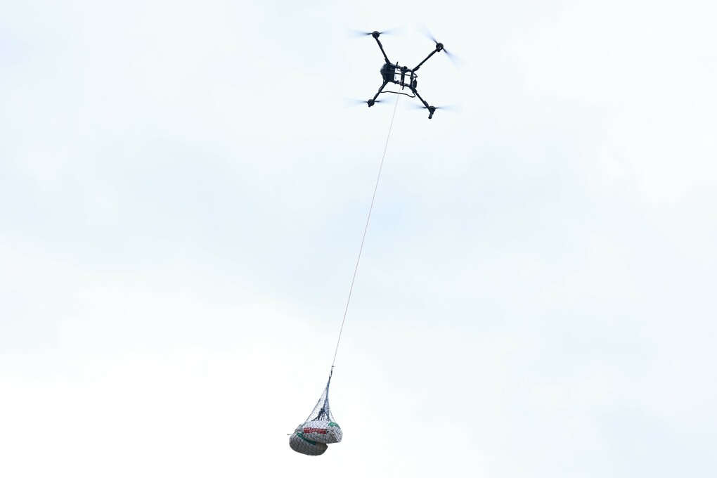 Những bao cà phê sau thu hoạch được vận chuyển từ vùng sản xuất xuống núi bằng UAV. Ảnh: Đàm Minh