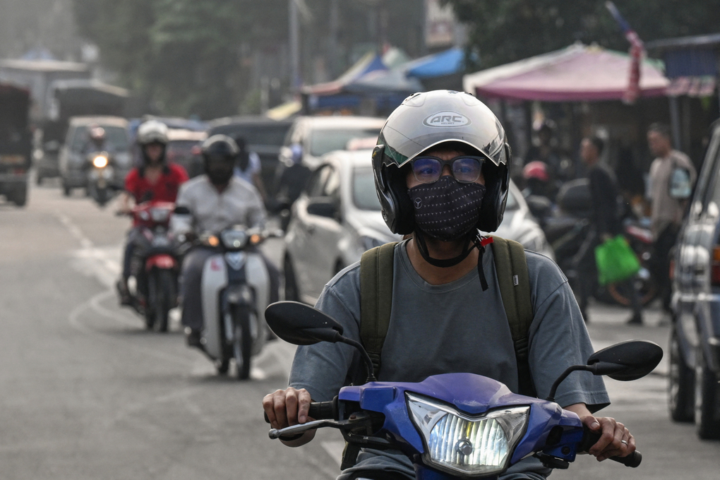 Người dân đeo khẩu trang khi di chuyển trên đường phố Kuala Lumpur dày đặc khói mù vì cháy rừng hôm 17/10. Ảnh: AFP